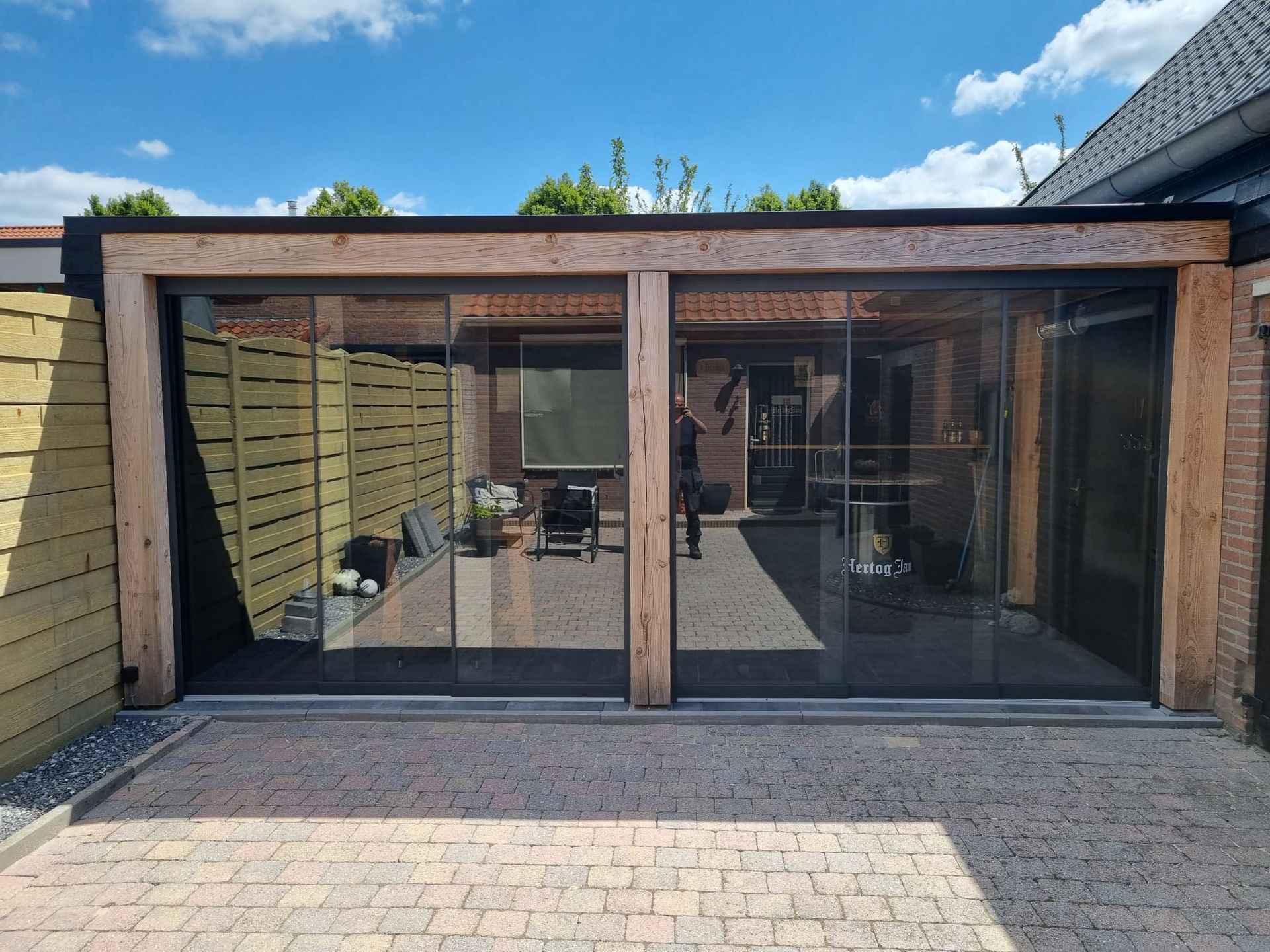 Een huis met veel ramen en een stenen oprit.