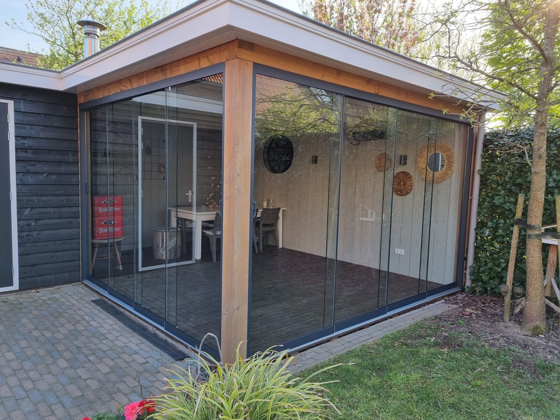 Een huis met een patio met glazen schuifdeuren en een tafel en stoelen.