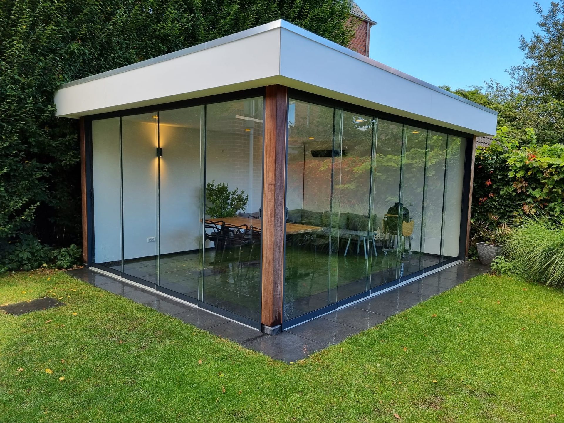 Een groot gebouw met veel ramen staat op een weelderig groen gazon.