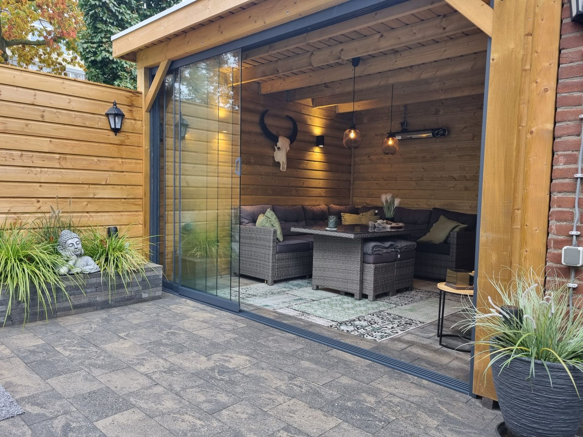 Een patio met een bank, tafel, stoelen en een glazen schuifdeur.