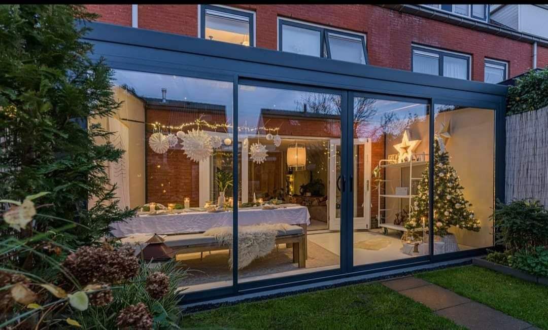 Er staat een kerstboom in de achtertuin van een huis.