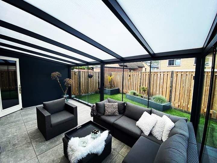 Een woonkamer met een bank, stoelen en een tafel.