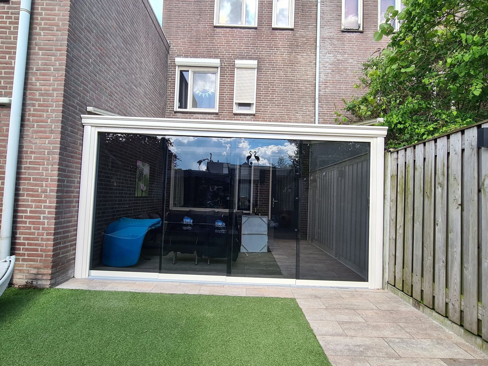 Een bakstenen gebouw met een glazen schuifdeur in de achtertuin.