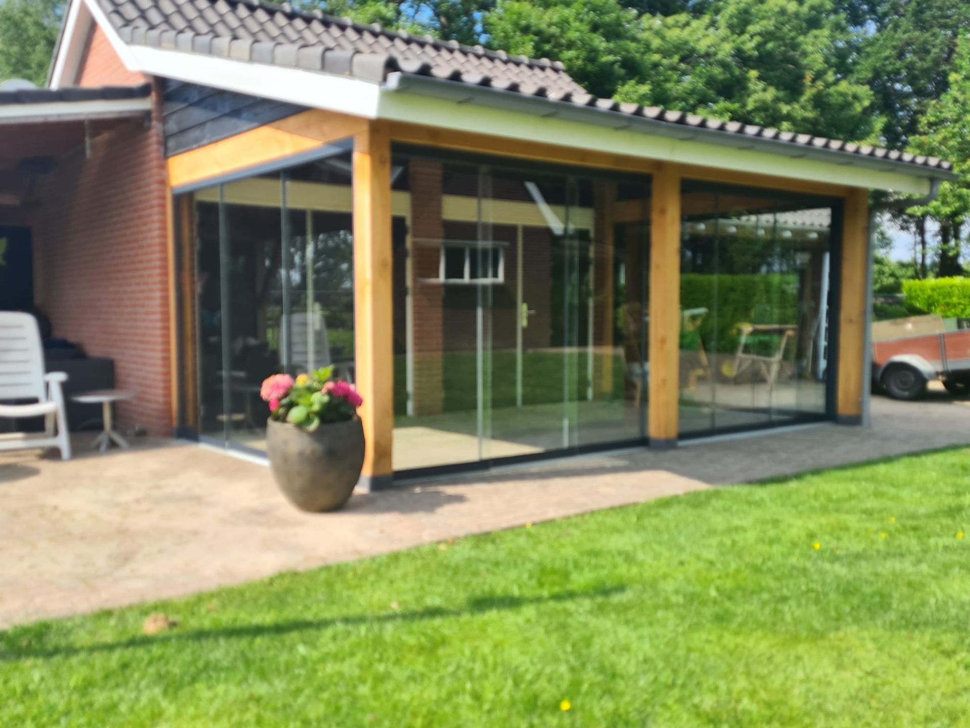 Een huis met een terras en een potplant ervoor