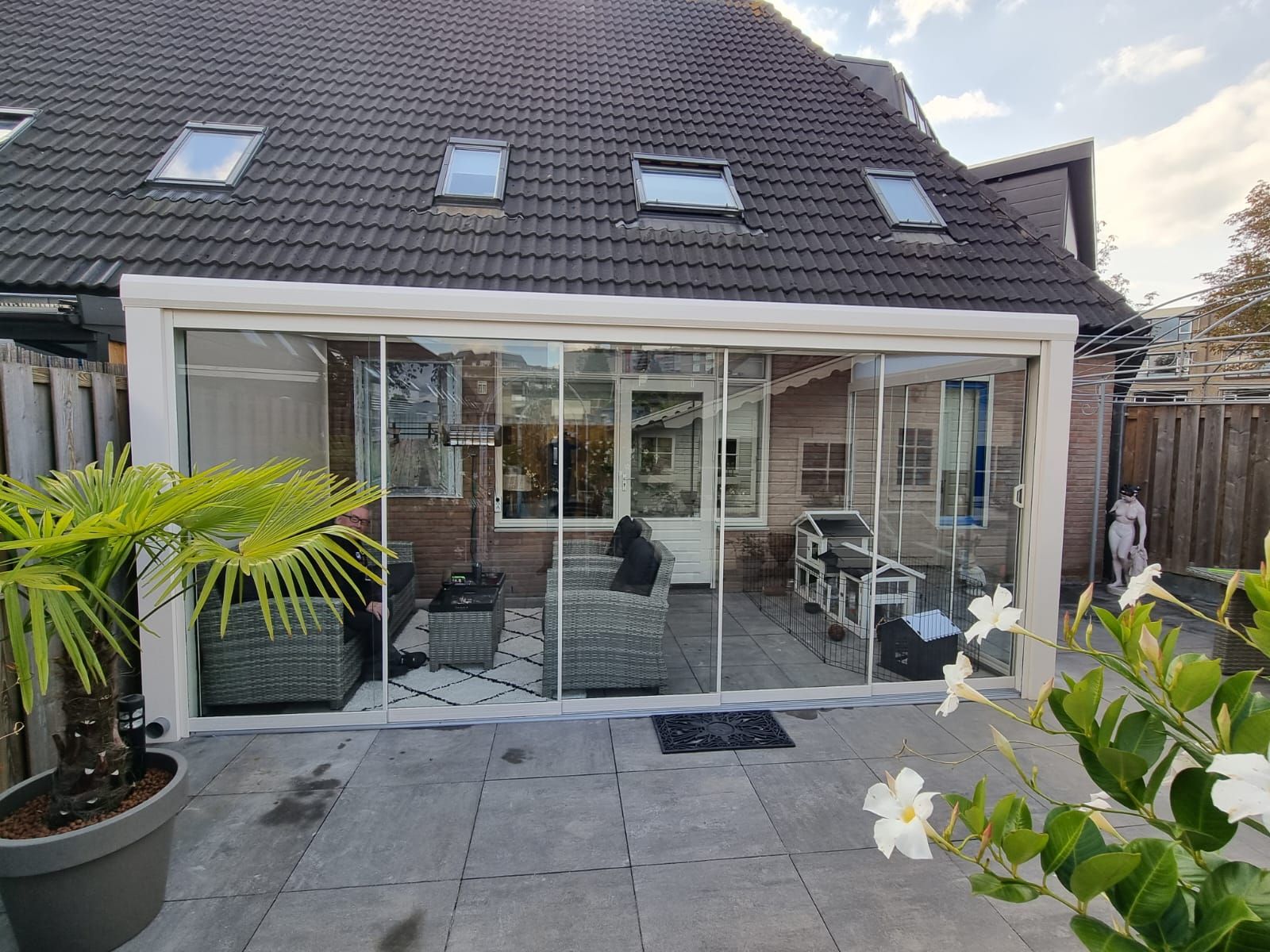 Een huis met een grote glazen schuifdeur die naar een patio leidt.