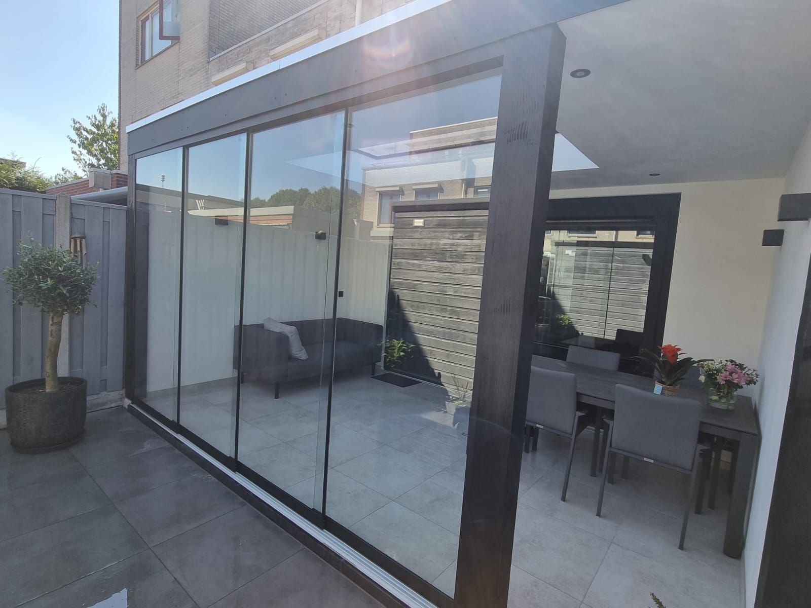 Een kamer met daarin een bank, tafel en stoelen.