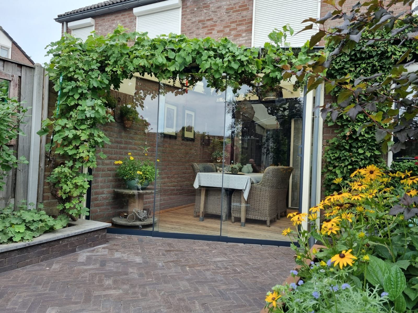 Een patio met een tafel en stoelen voor een huis.