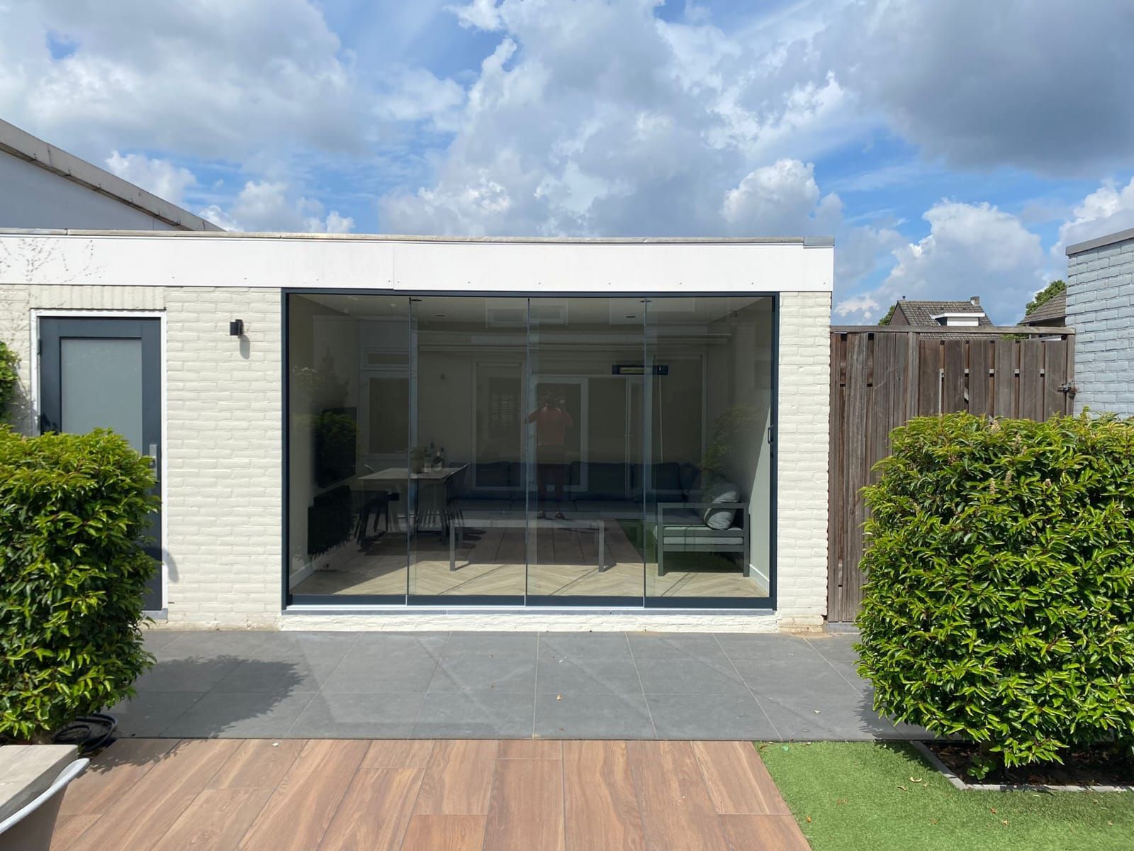 Een huis met een glazen schuifdeur en een bank in de woonkamer.