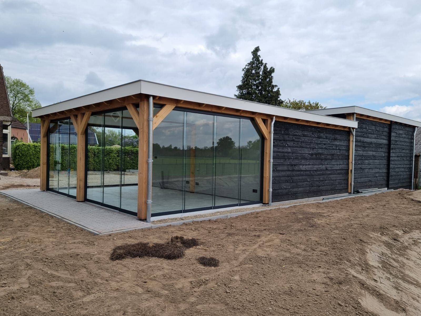 Een groot gebouw met veel ramen staat op een zandveld.