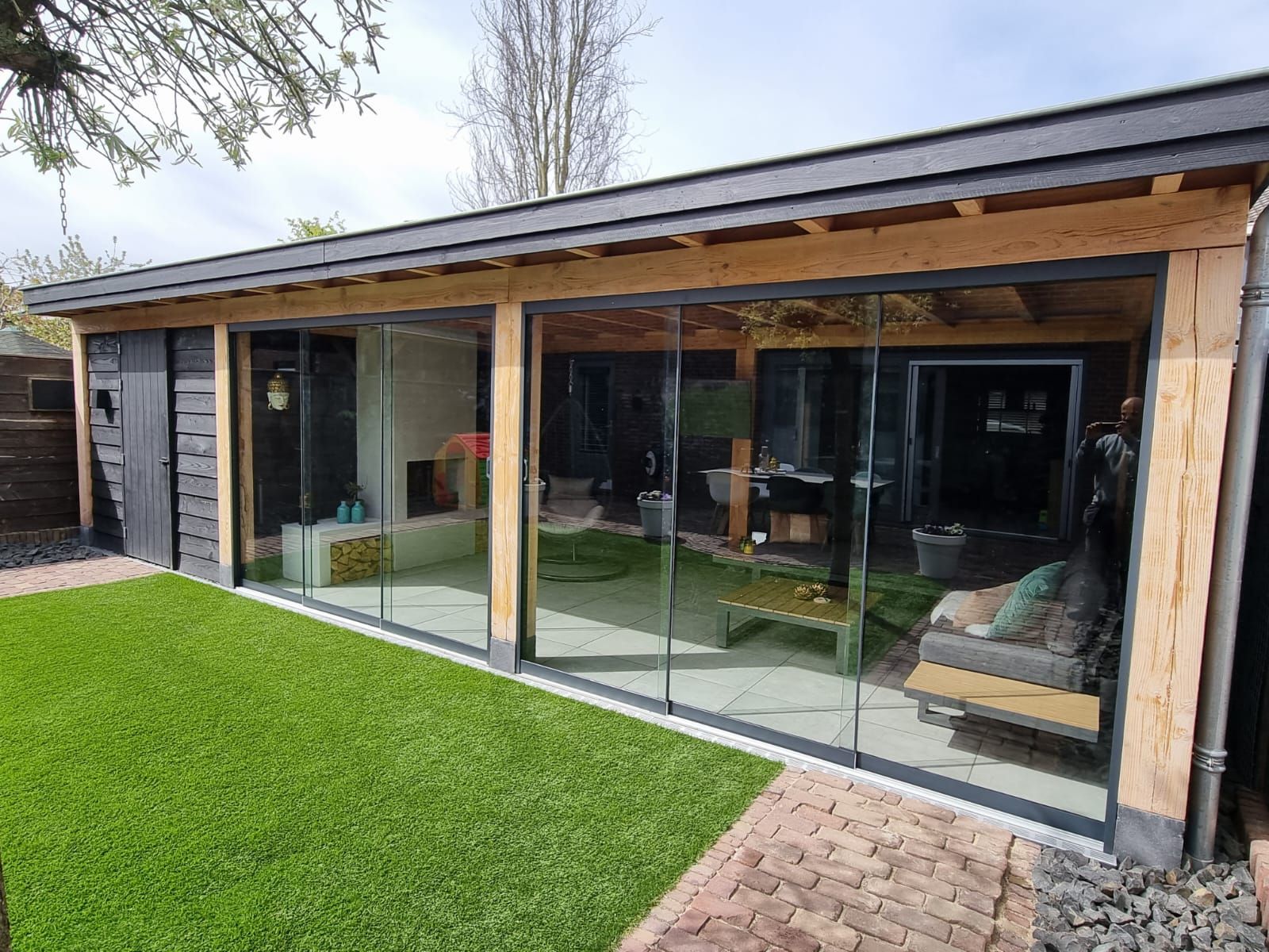 Een groot huis met veel ramen en glazen schuifdeuren.