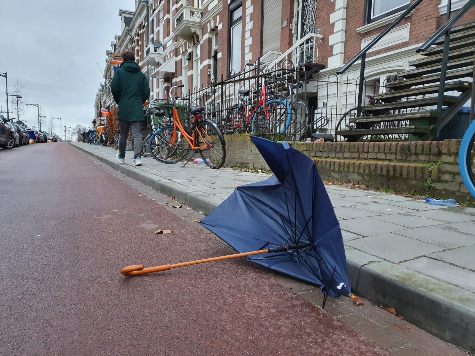 Een blauwe paraplu ligt aan de kant van de weg