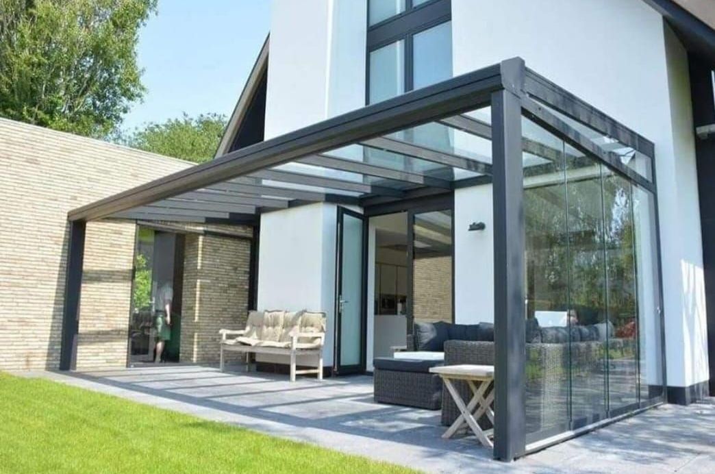 Een moderne woning met een overdekt terras met glazen dak.