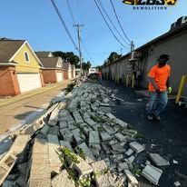 A man in an orange shirt is walking down a damaged street.