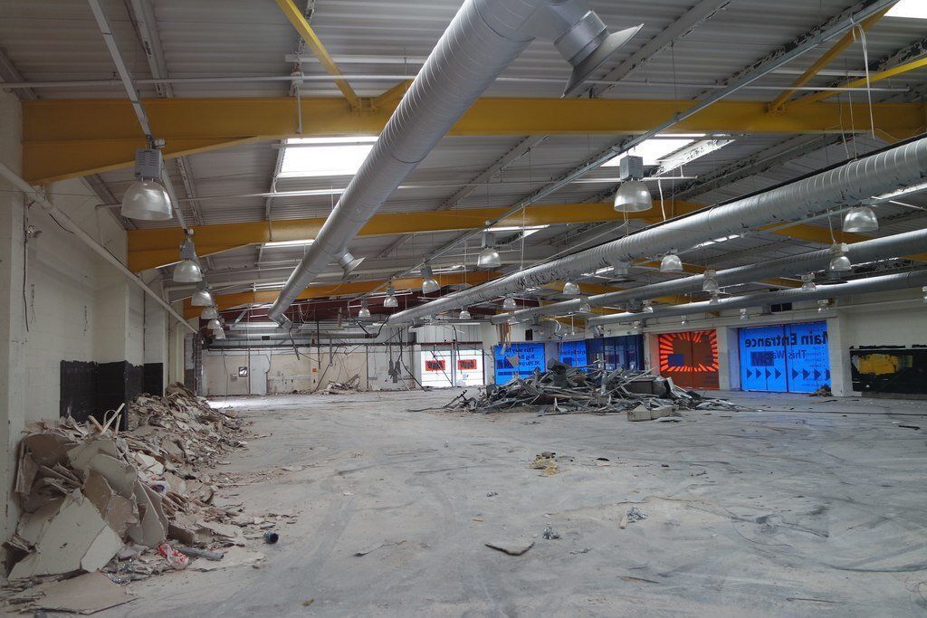 A large empty warehouse with a lot of wires hanging from the ceiling