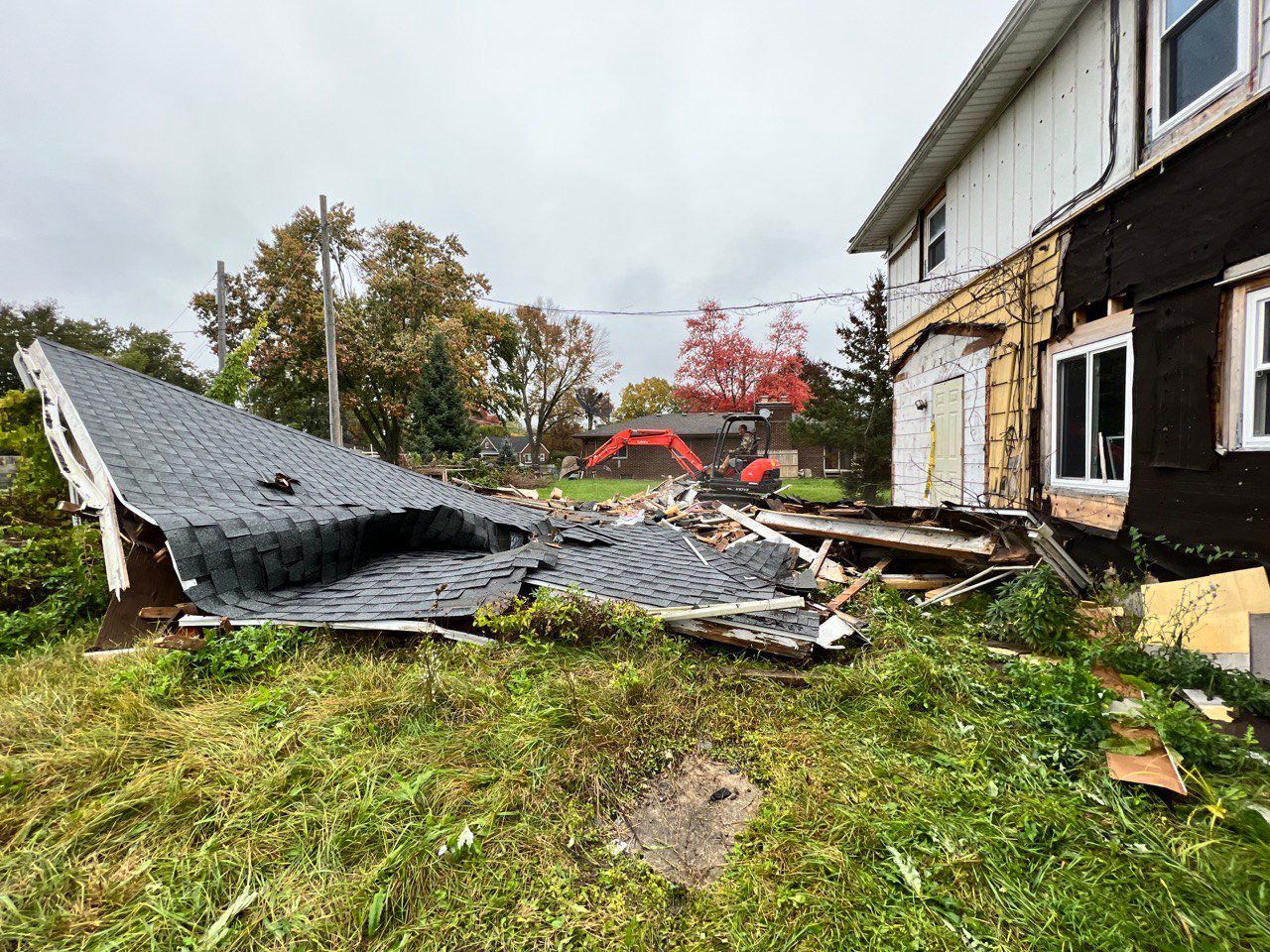 A house with a roof that has fallen off is being demolished.