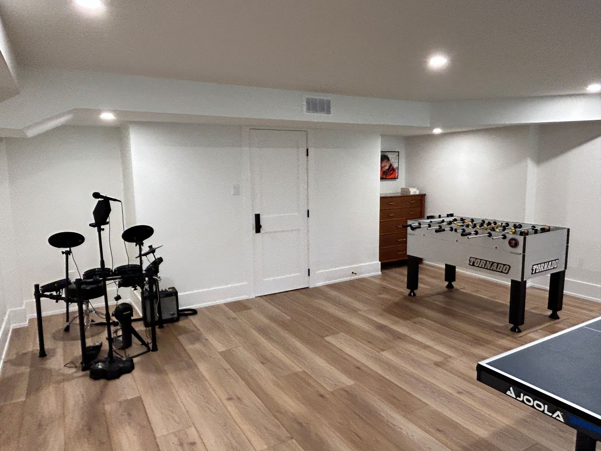 Game room with a foosball table, electronic drum set, and ping pong table.