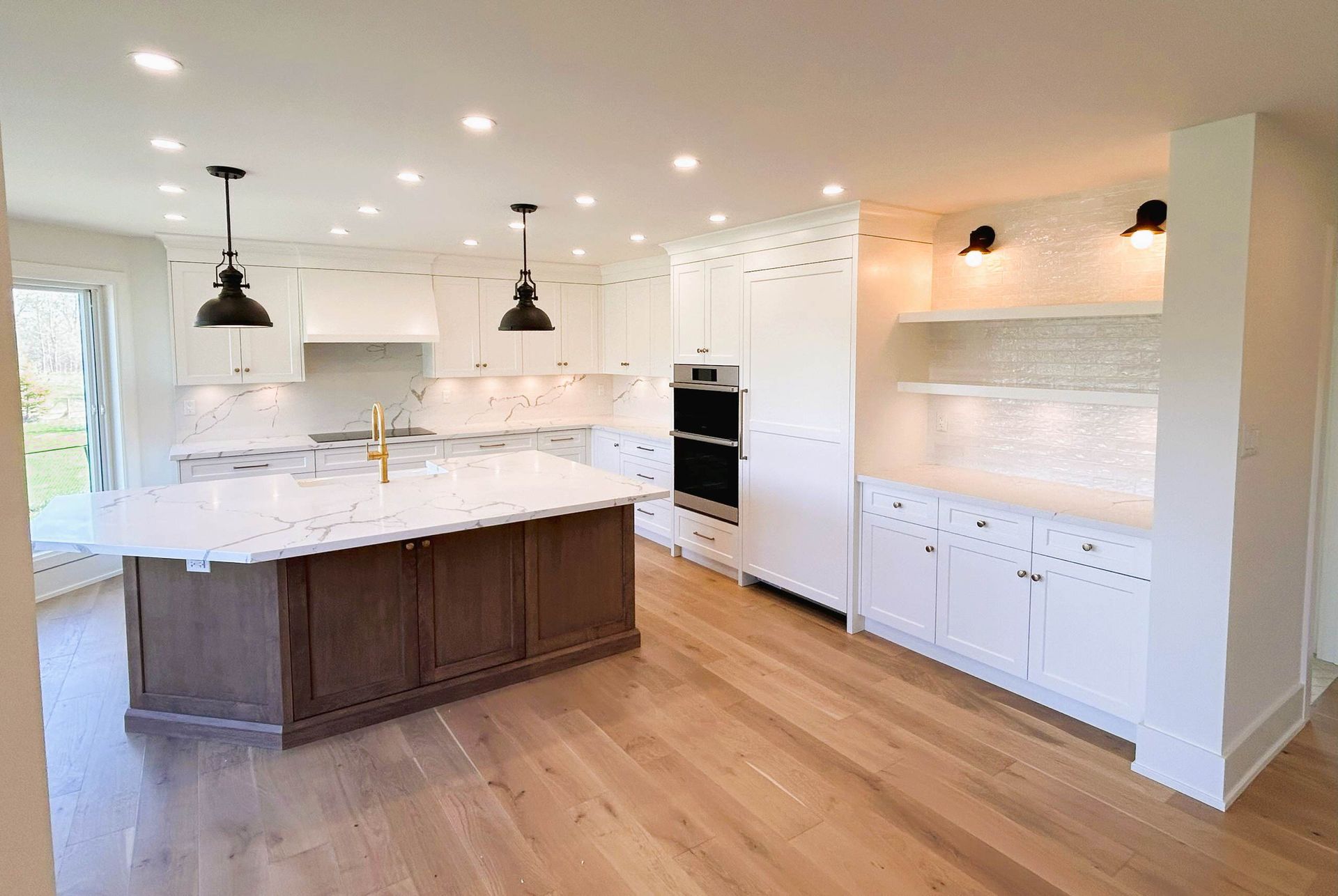 Modern kitchen with white cabinets, wood island, and hardwood floors.