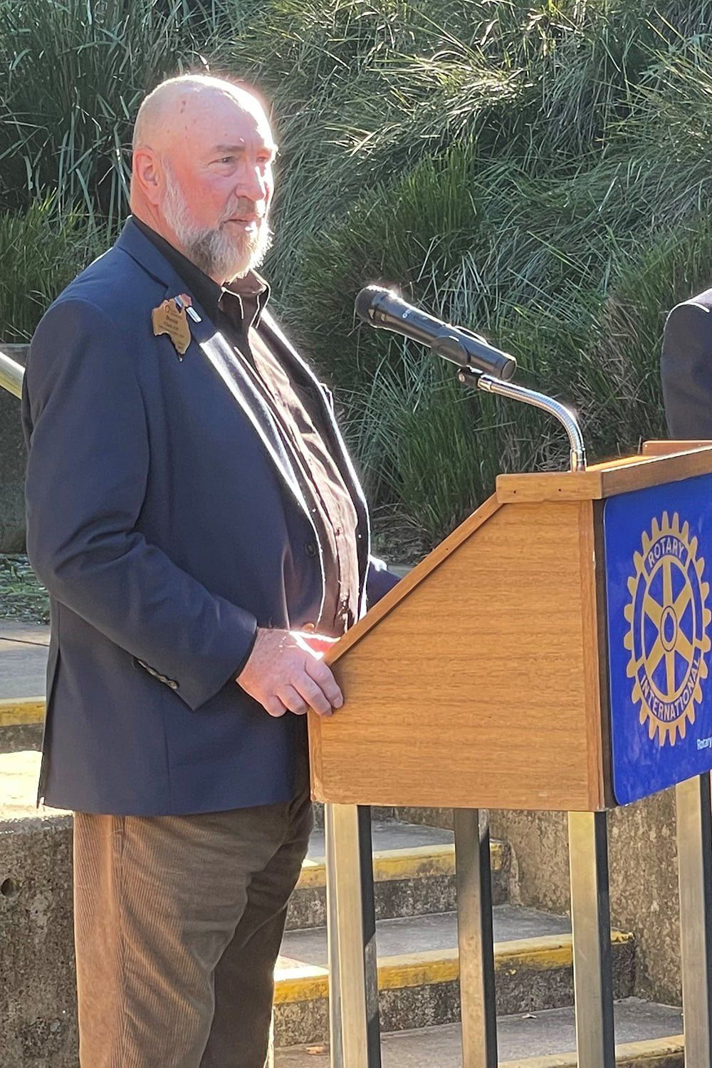 A man is standing at a podium talking into a microphone.