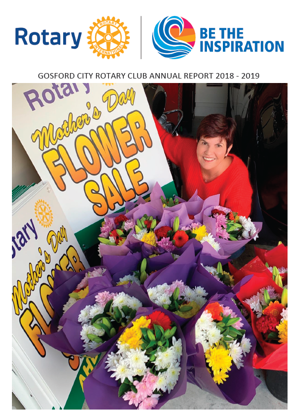 A woman is standing in front of a bunch of flowers.