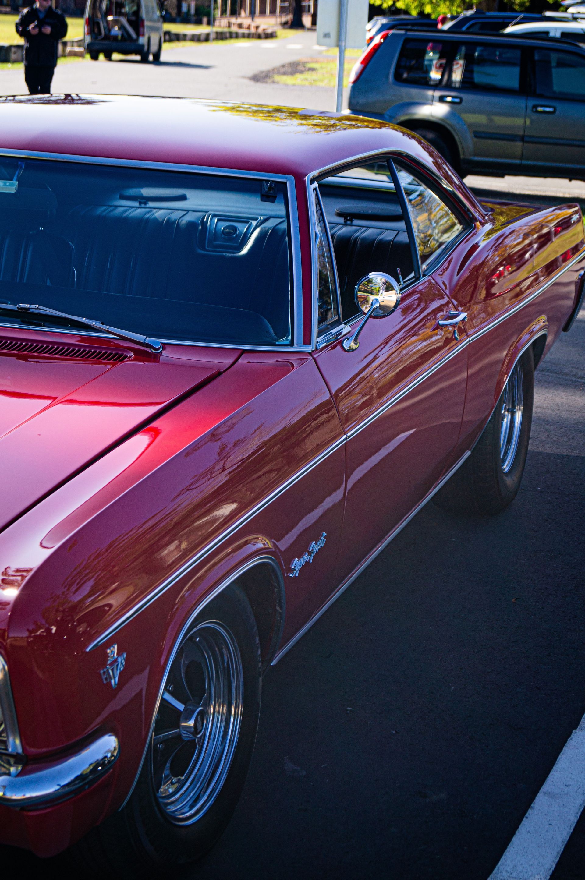 A red car is parked in a parking lot.