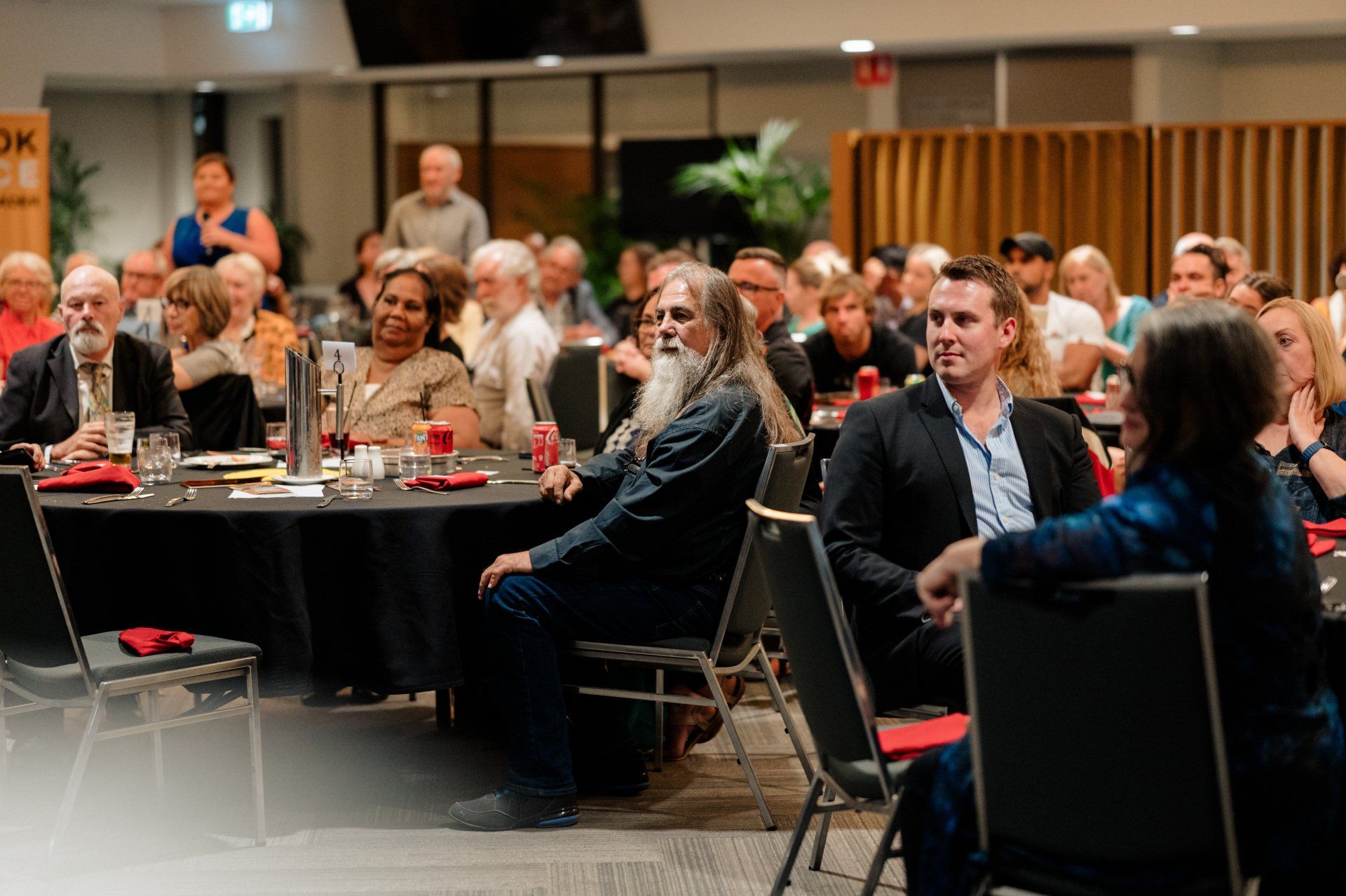 A group of people are sitting at tables in a room.