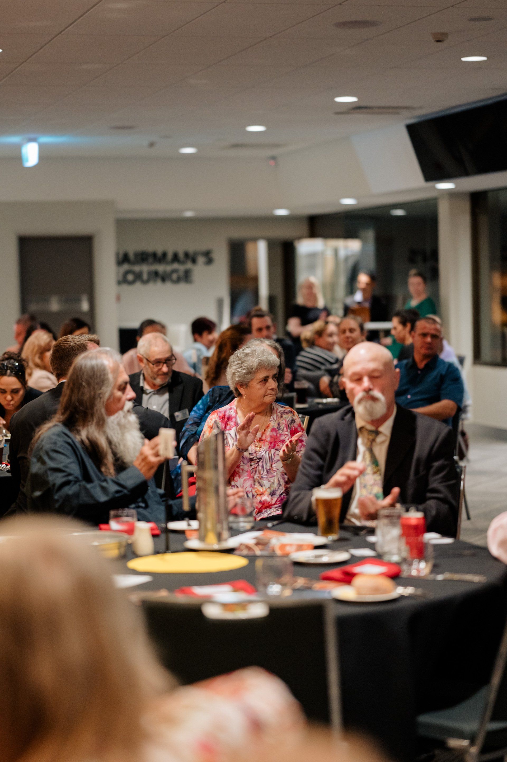 A group of people are sitting at tables in a room.