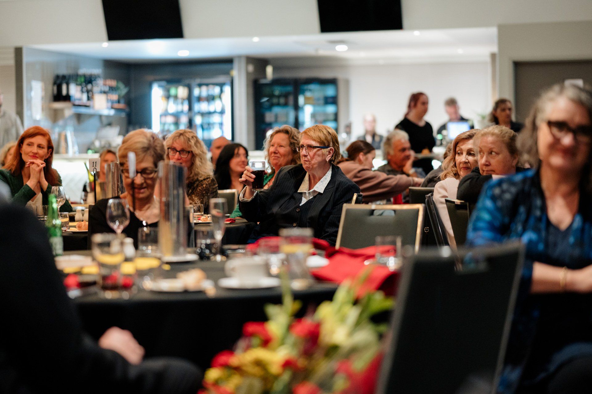 A group of people are sitting at tables in a restaurant.