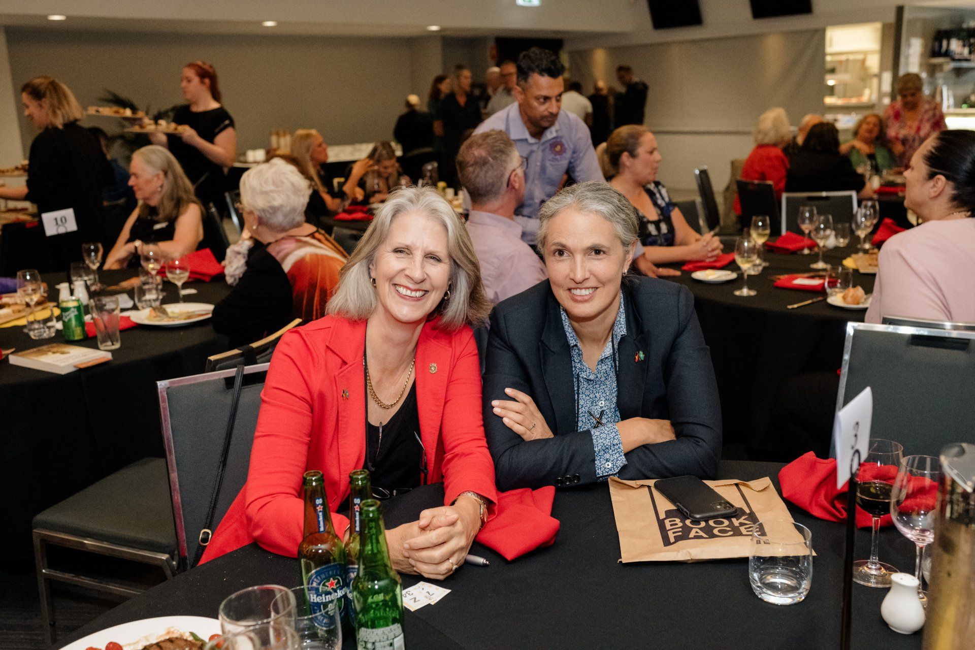 Two women are sitting at a table in a restaurant.