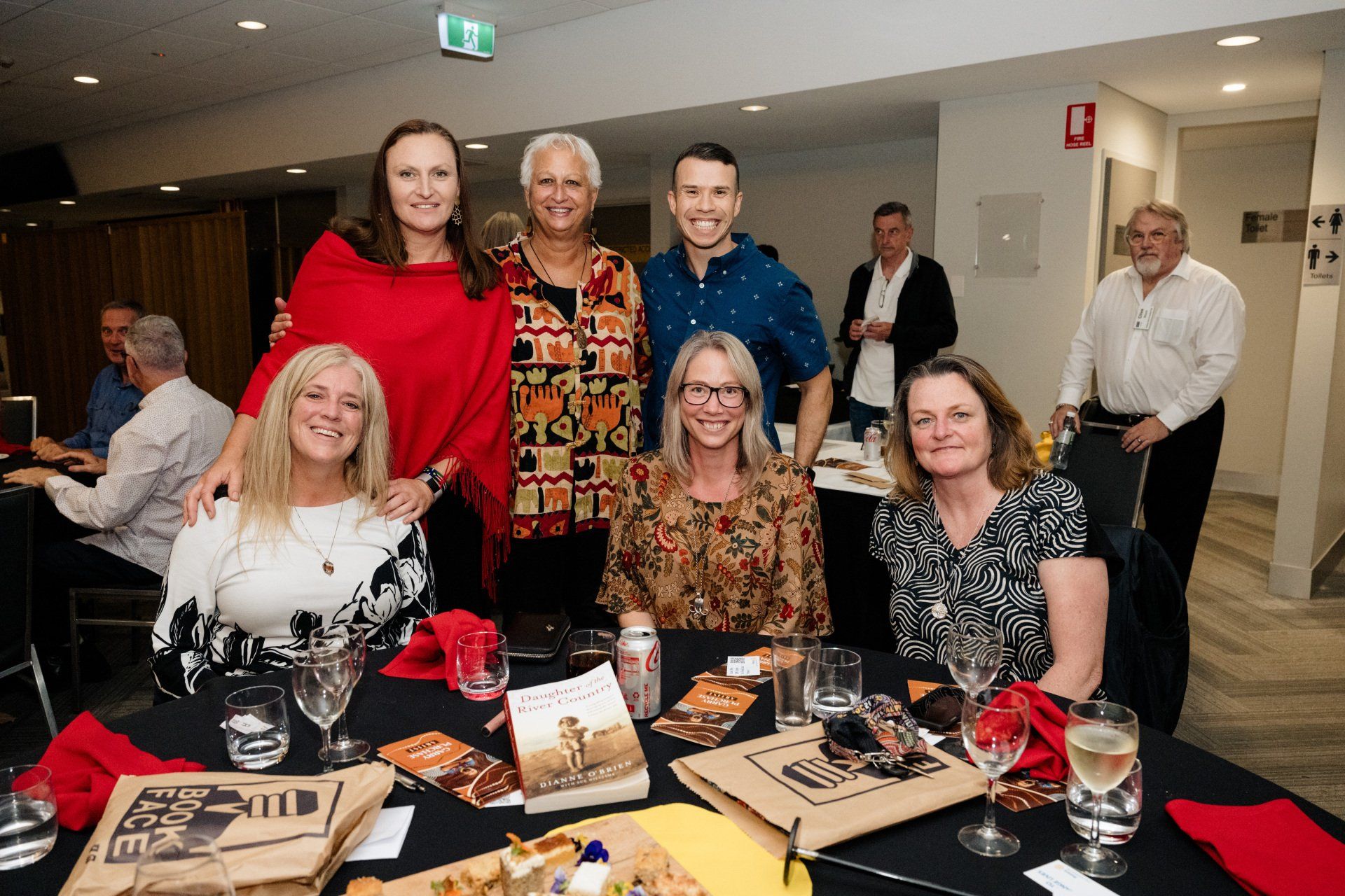 A group of people are posing for a picture at a table.