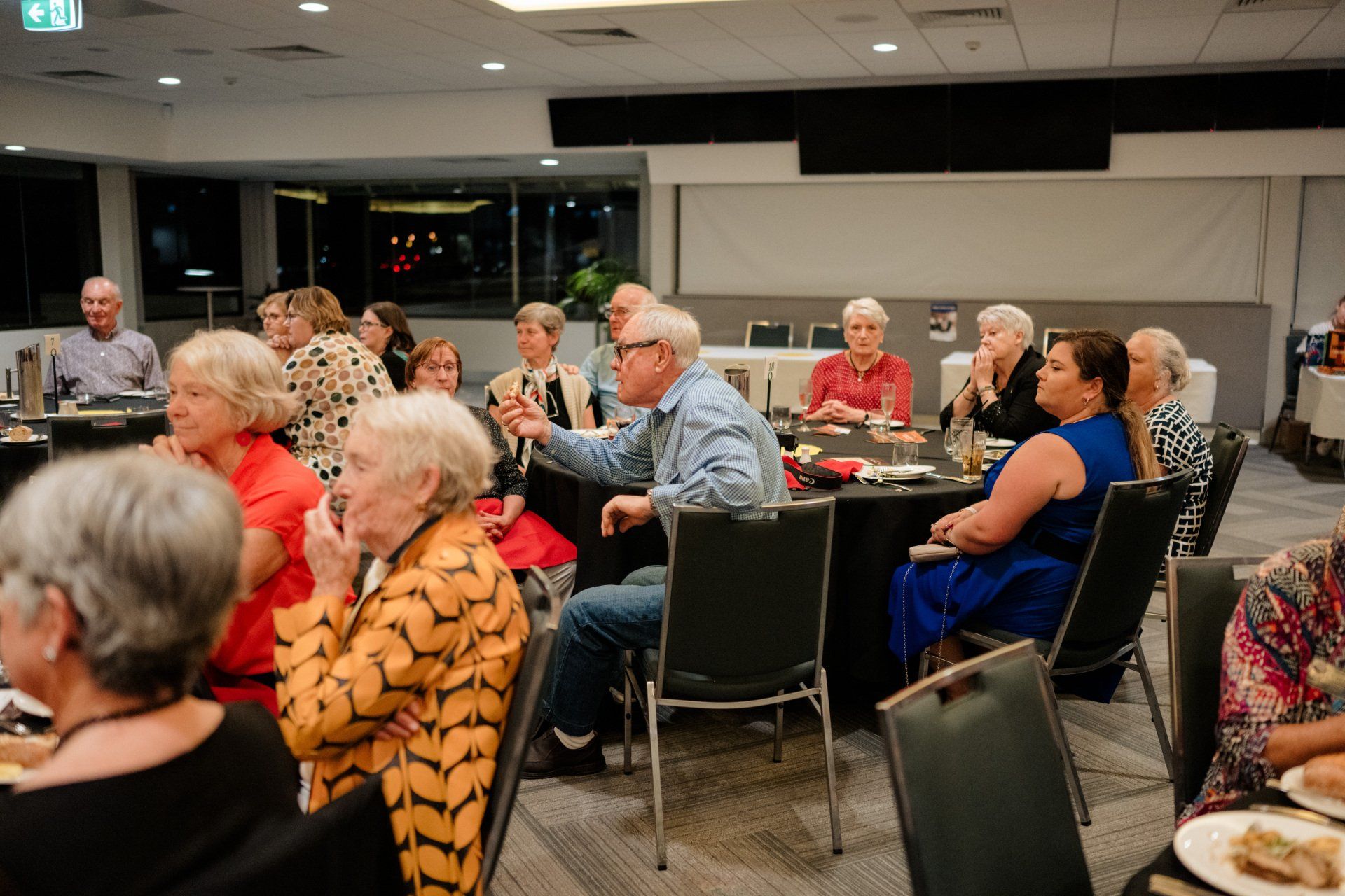 A group of people are sitting at tables in a room.