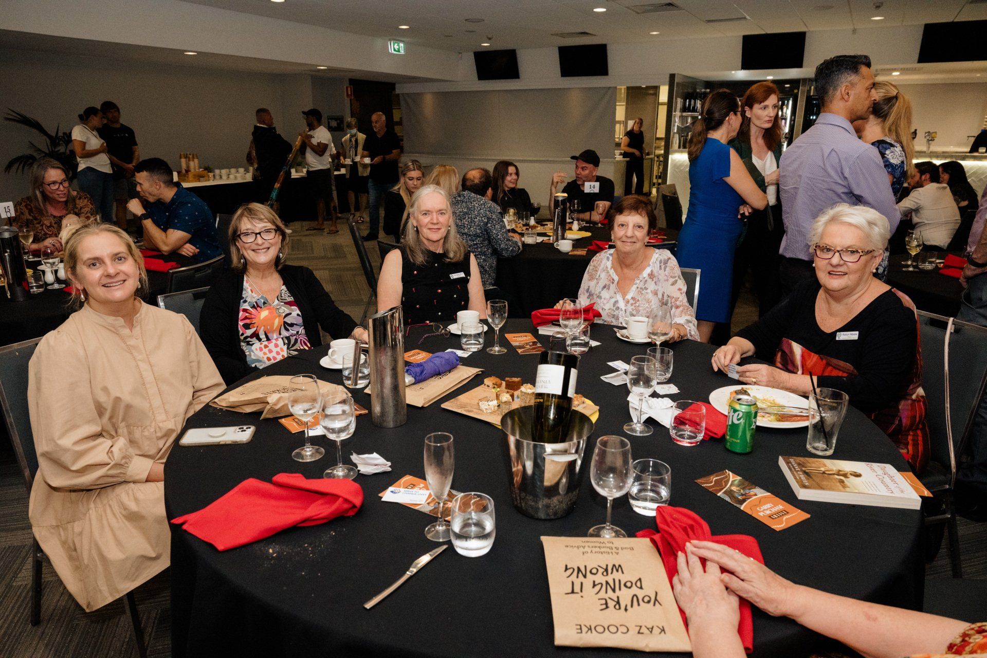 A group of people are sitting at a table at a party.