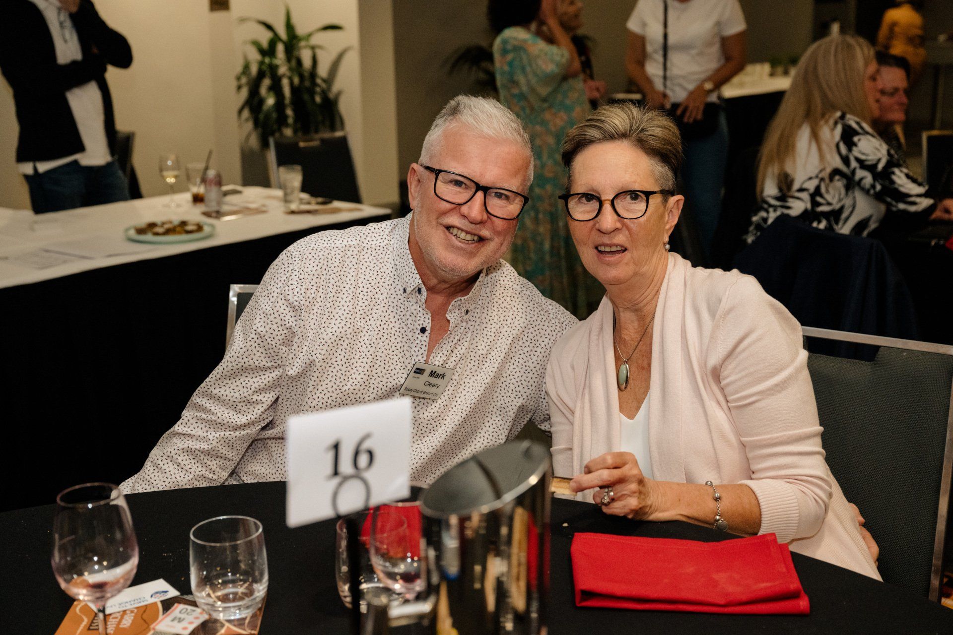 A man and a woman are sitting at a table with wine glasses.