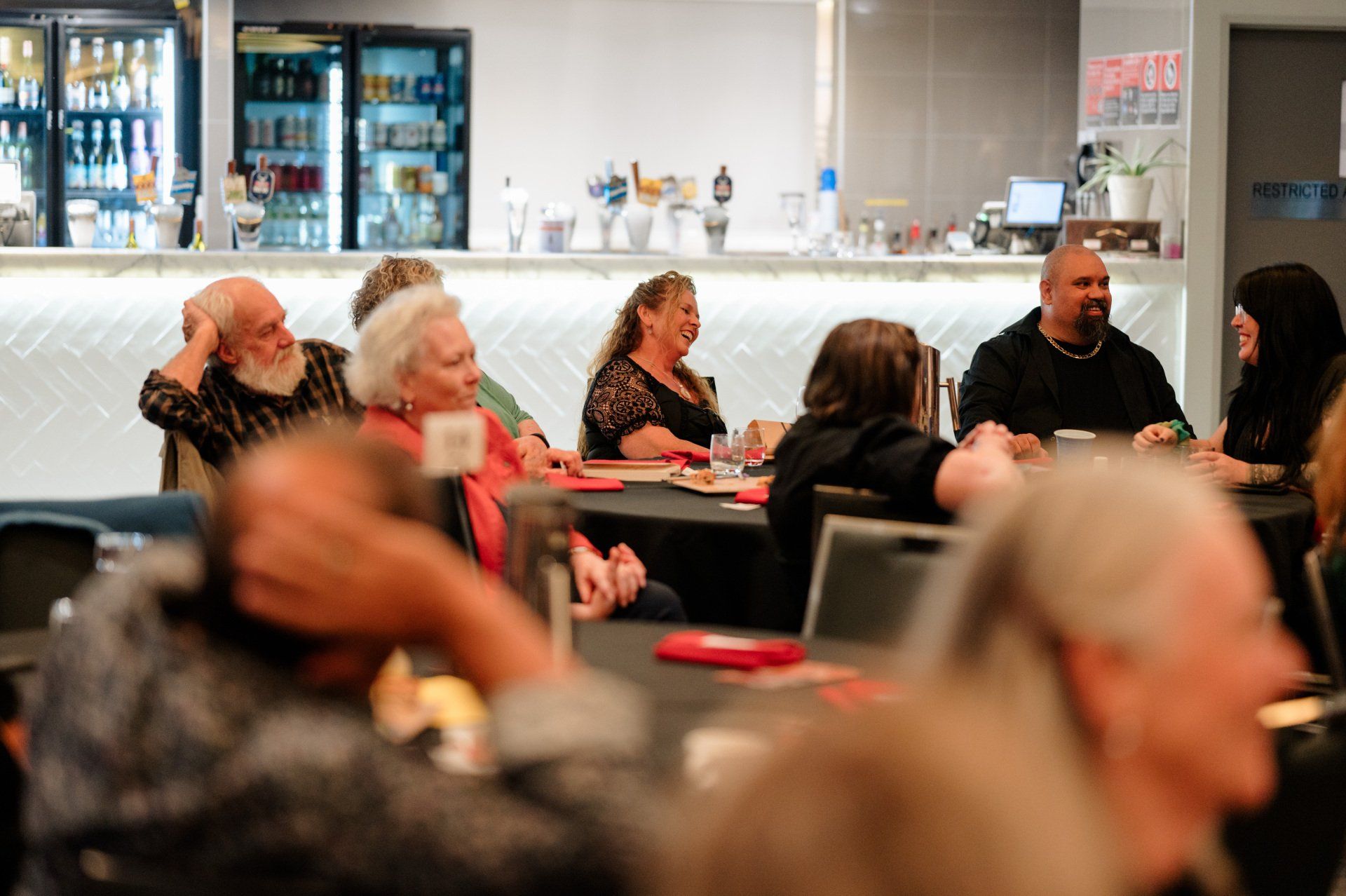 A group of people are sitting at tables in a restaurant.