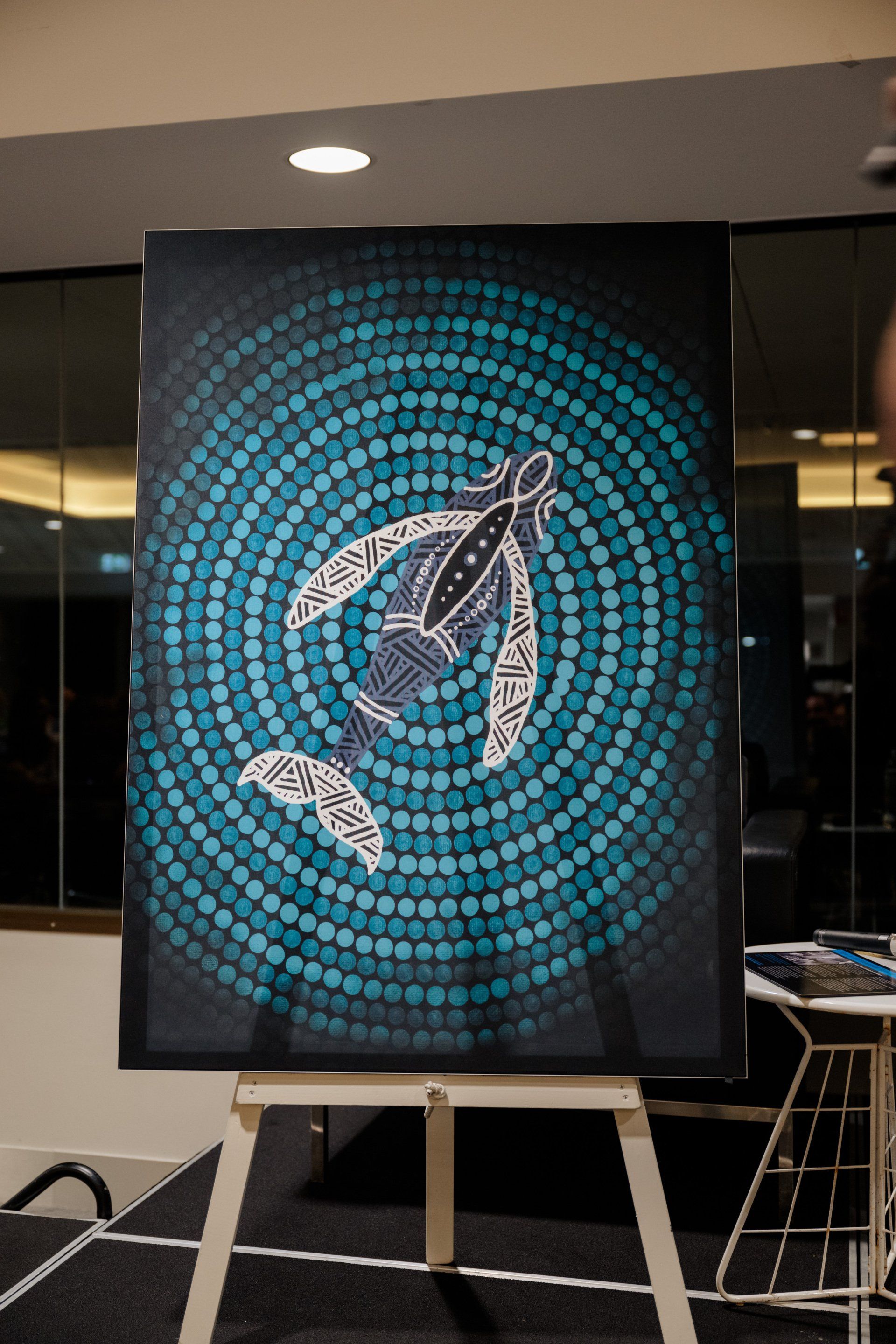 A painting of a whale is on an easel