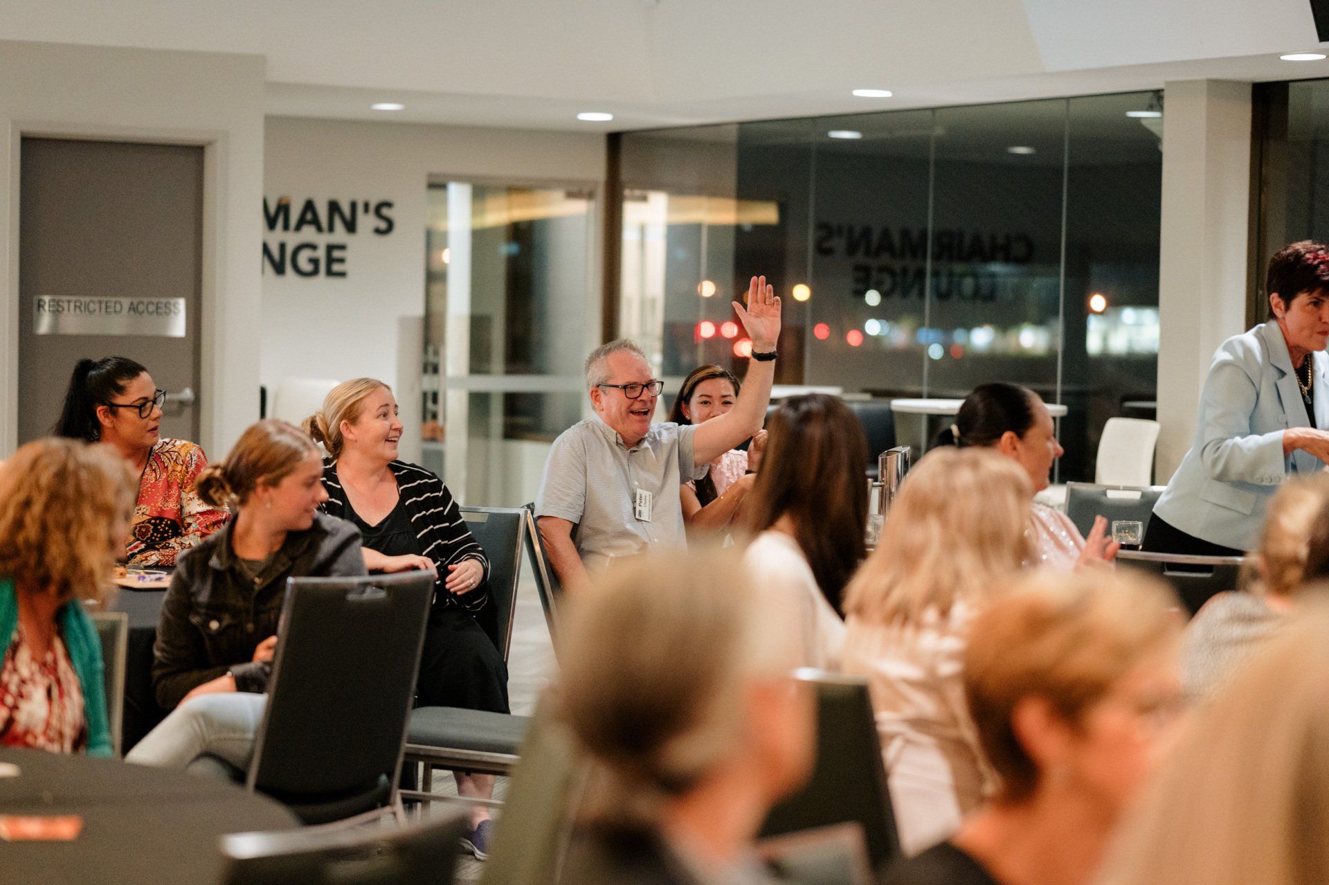 A group of people are sitting at tables in a room.
