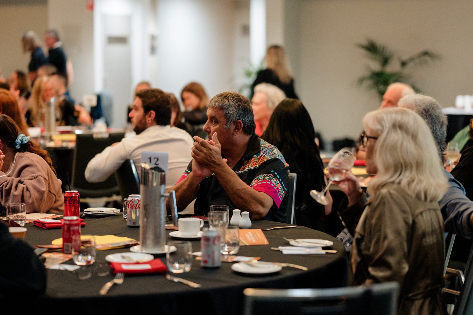 A group of people are sitting at tables in a room.