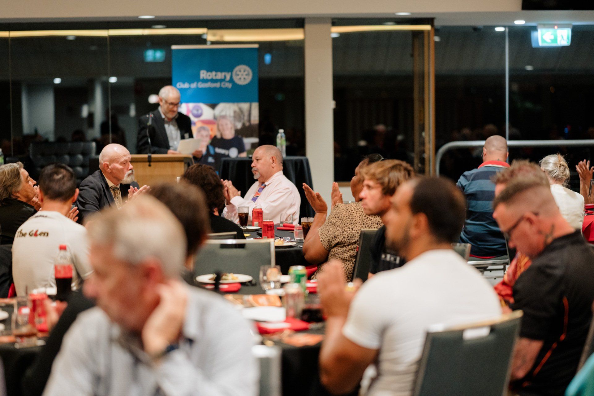 A group of people are sitting at tables in a room.
