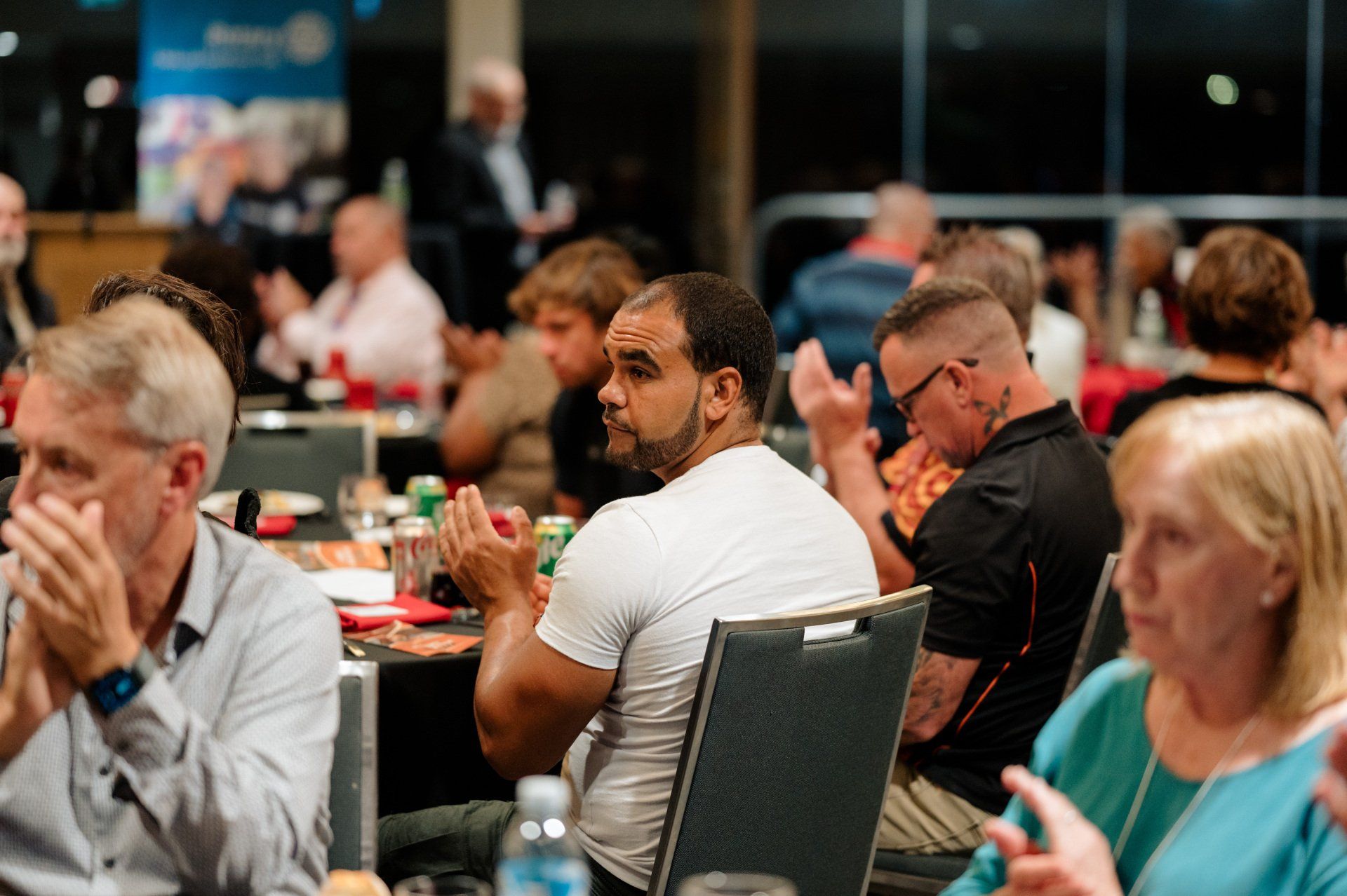 A group of people are sitting at tables in a room.