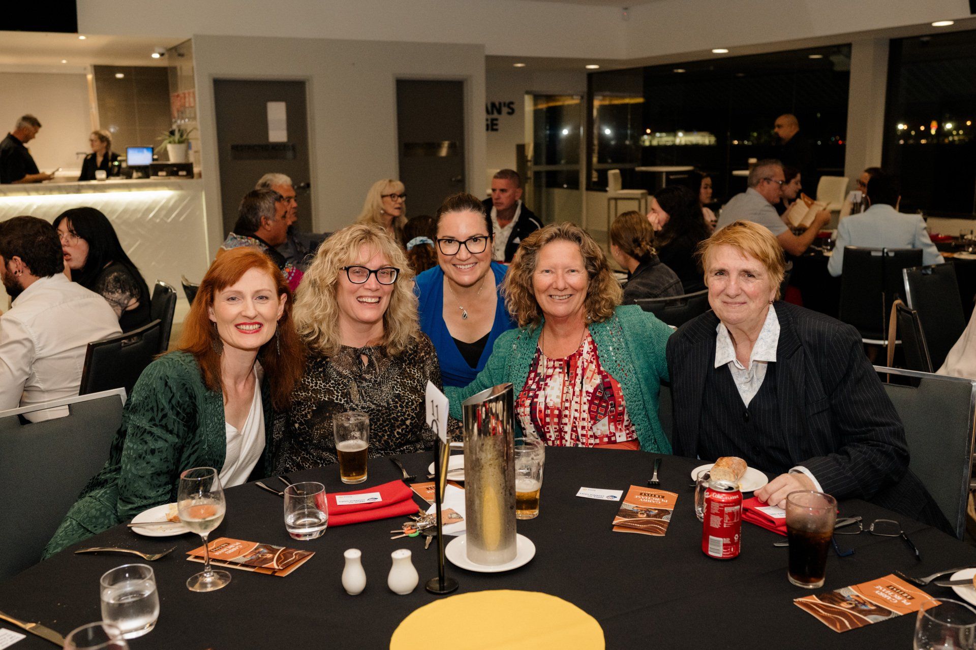 A group of women are posing for a picture at a table.