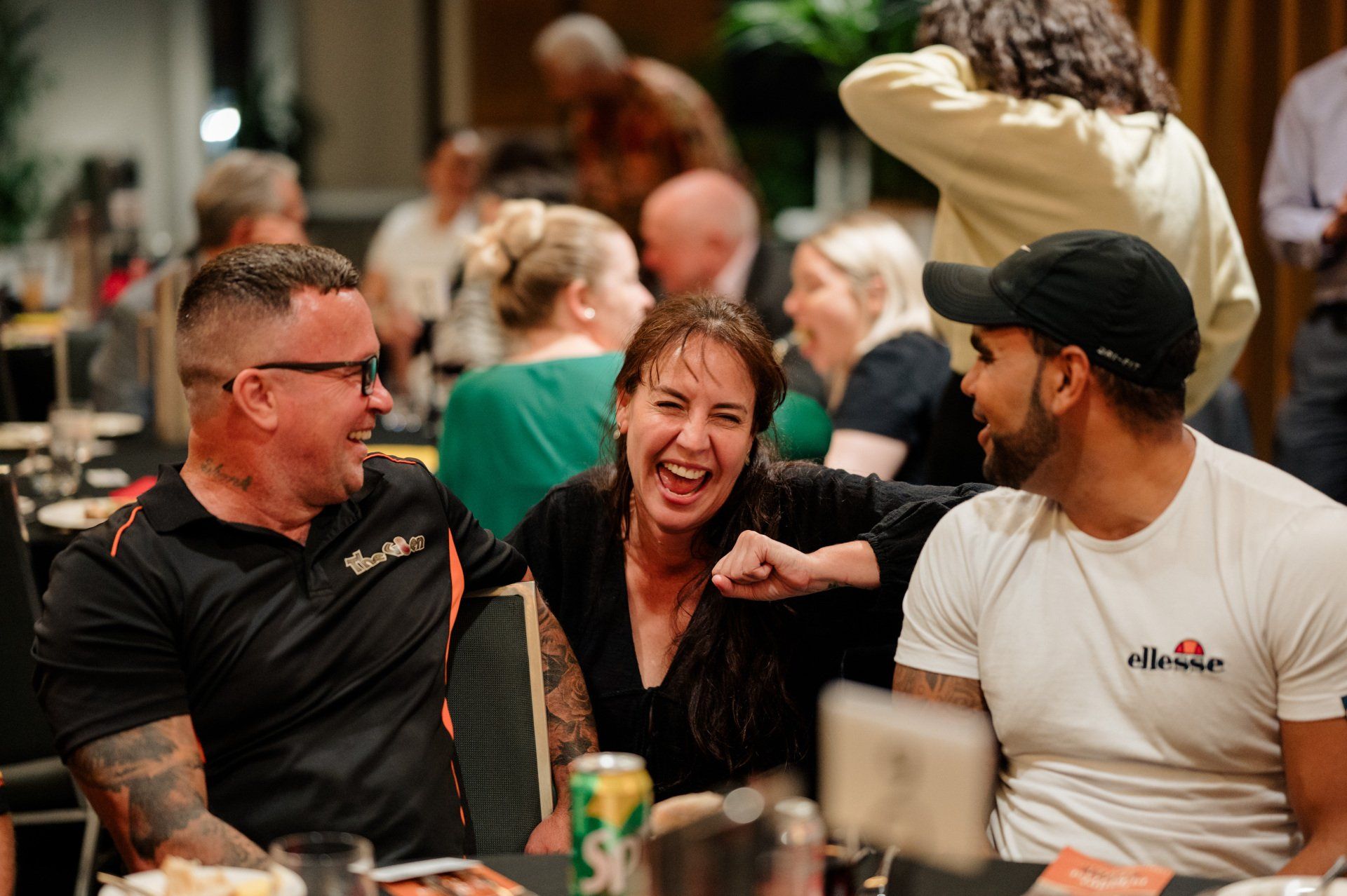 A group of people are sitting at a table laughing.