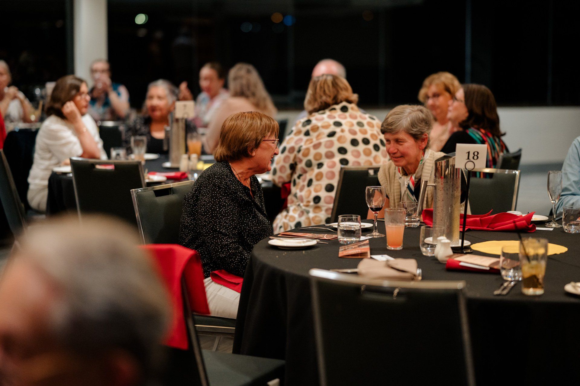 A group of people are sitting at tables in a restaurant.
