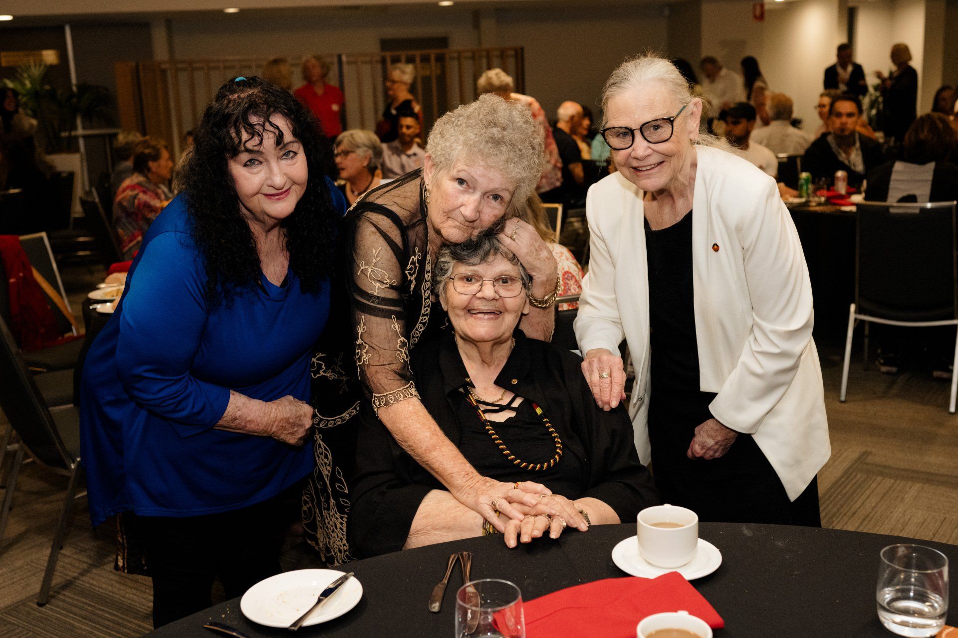 A group of women are posing for a picture at a table.