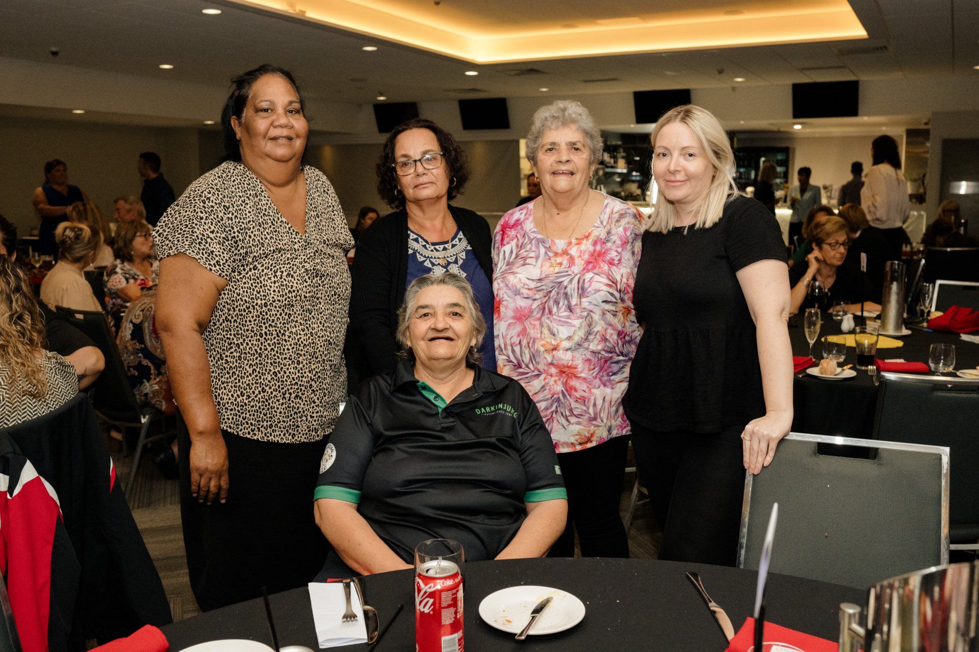 A group of women are posing for a picture at a table.