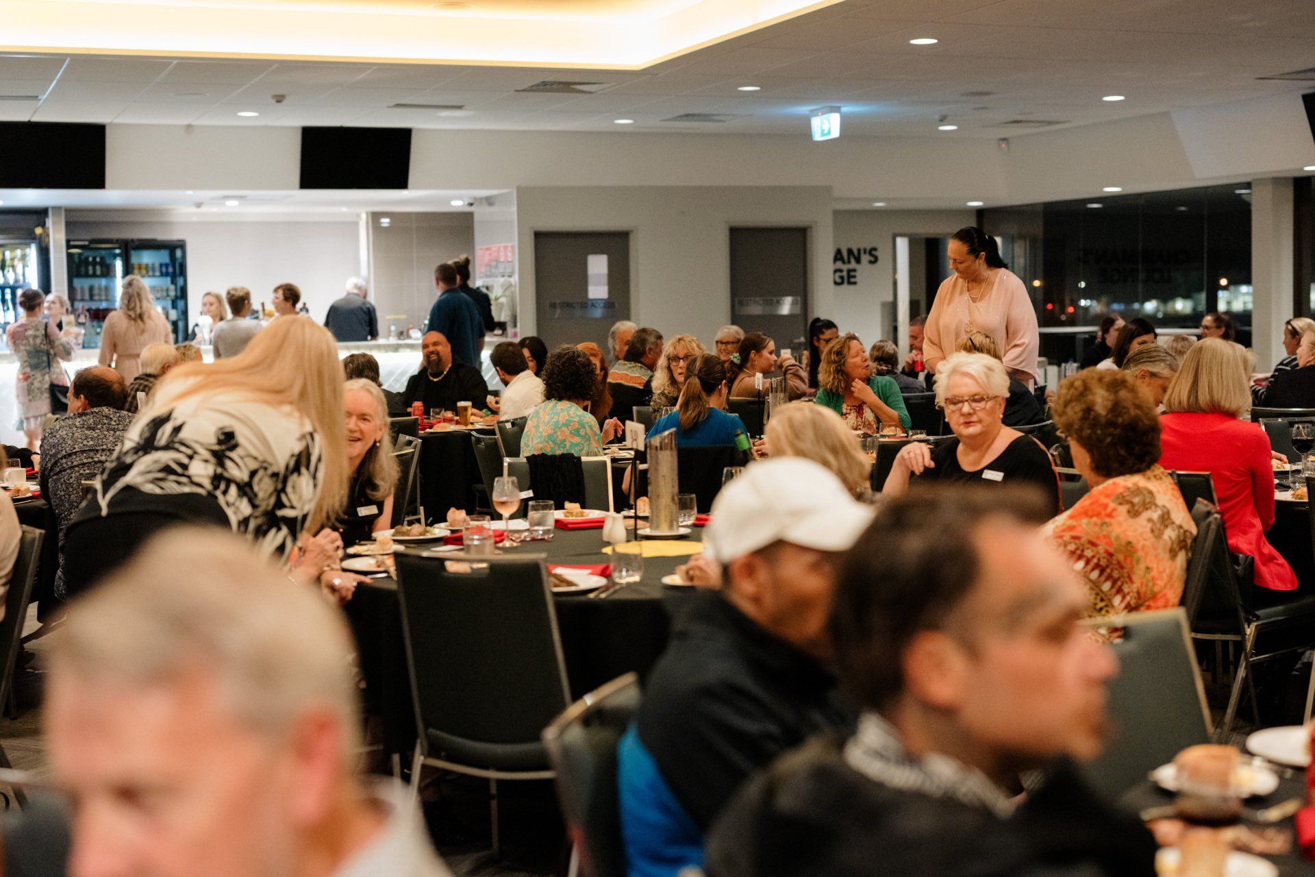 A large group of people are sitting at tables in a restaurant.