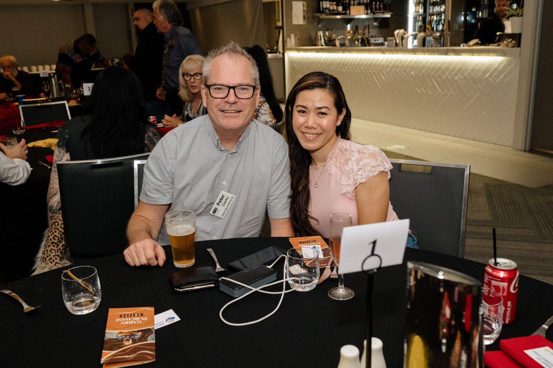 A man and a woman are sitting at a table in a restaurant.