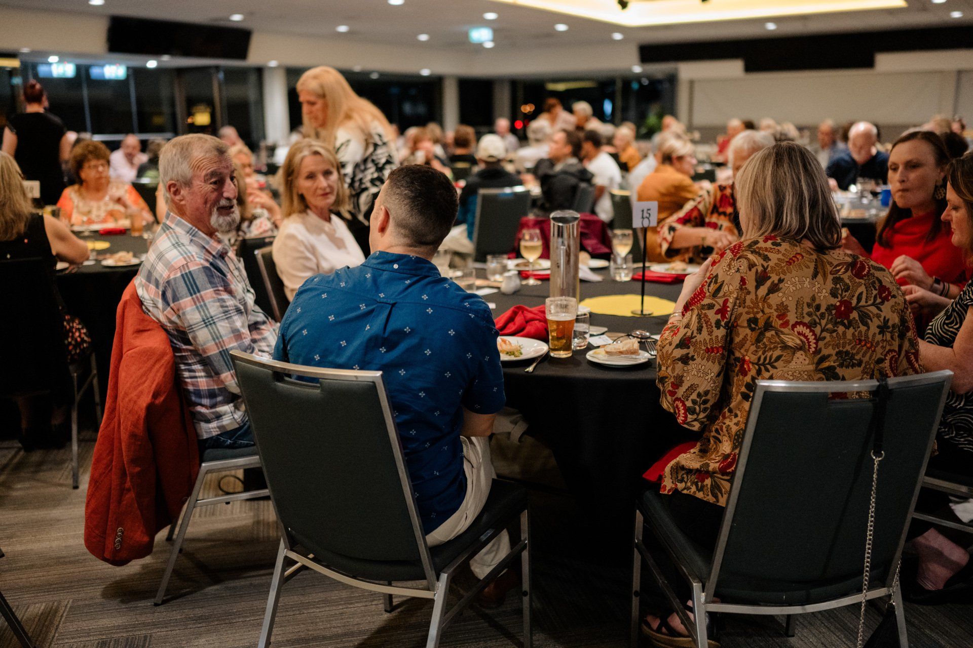 A group of people are sitting at tables in a restaurant.