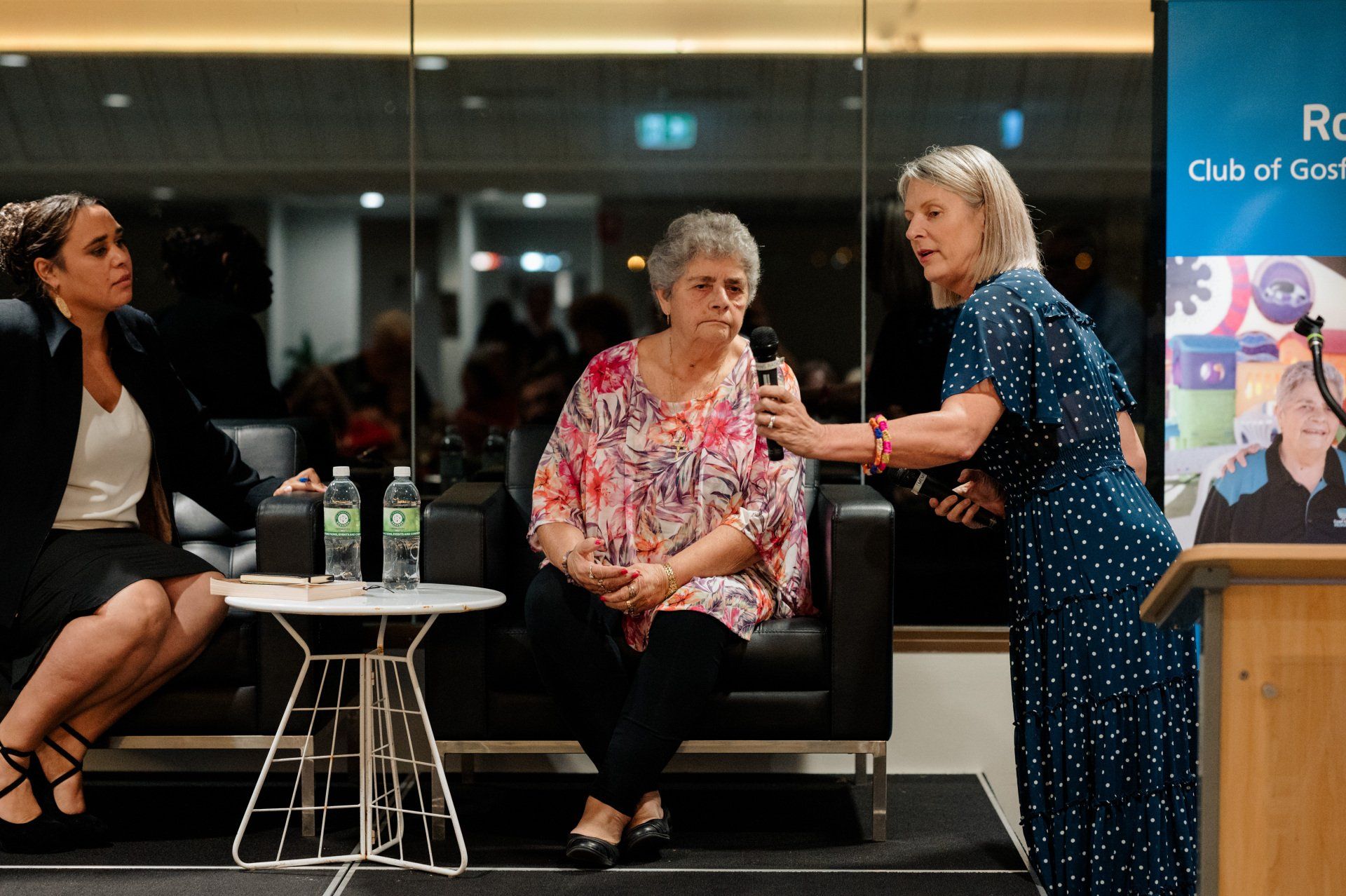 A group of women are sitting at a table and talking to each other.