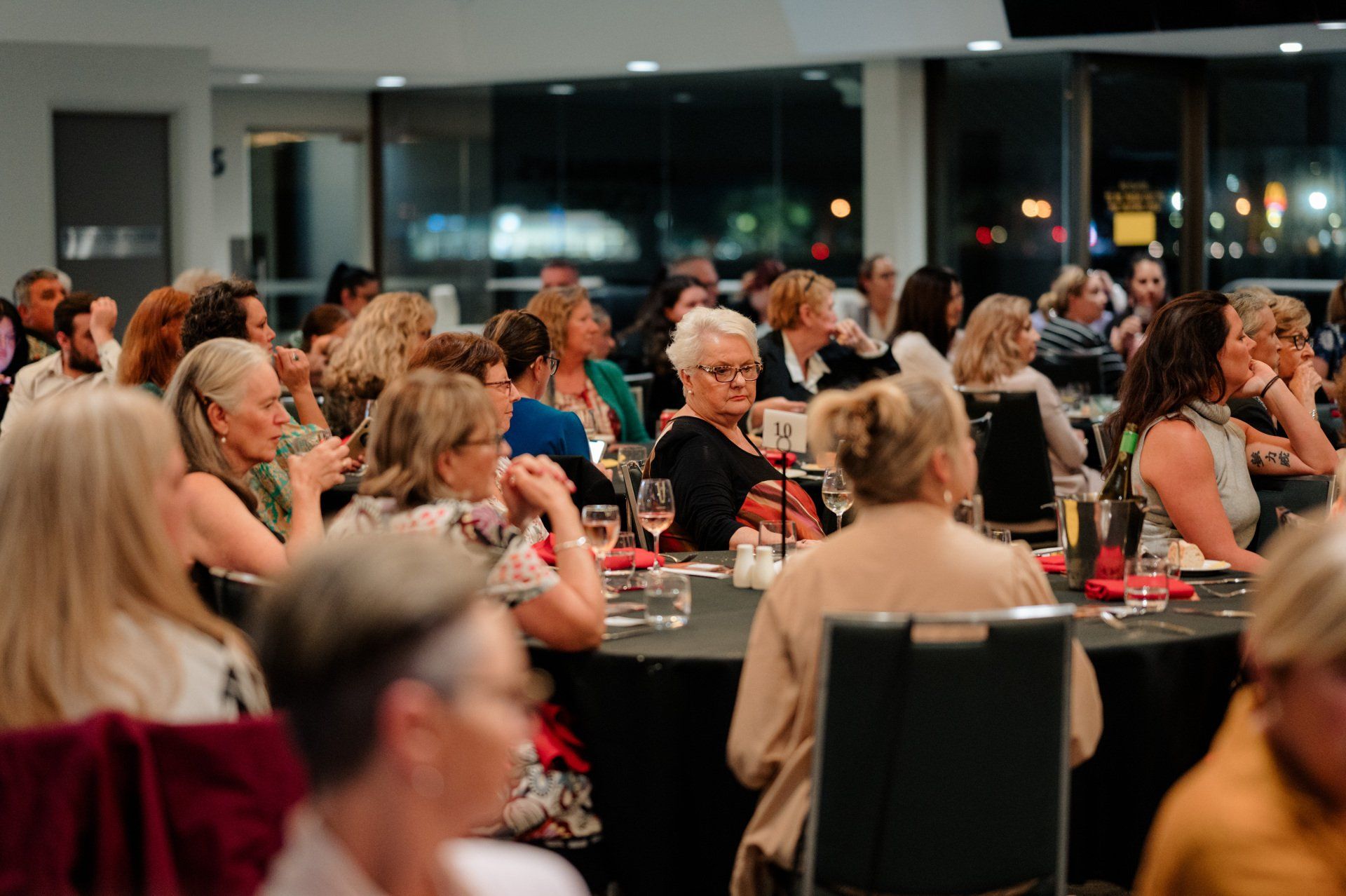 A large group of people are sitting at tables in a room.