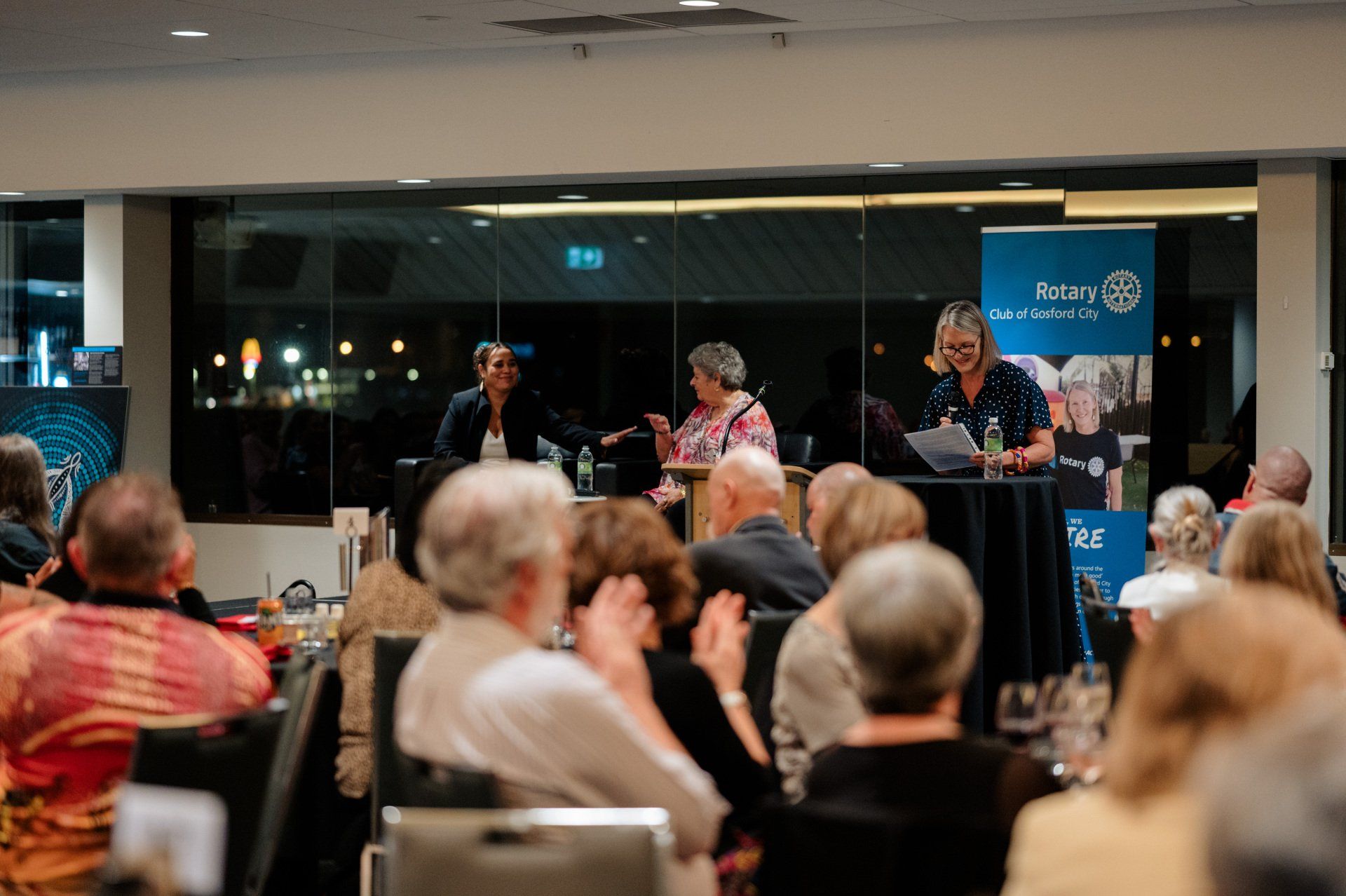 A group of people are sitting in a room watching a presentation.