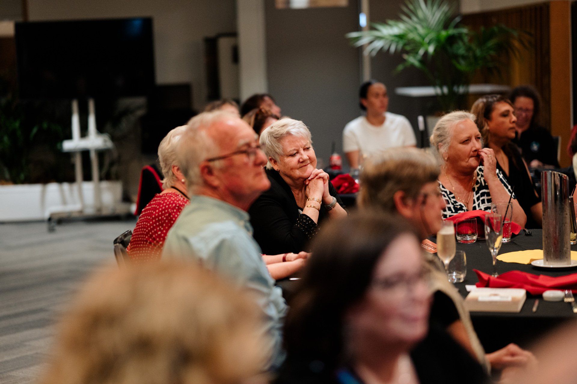 A group of people are sitting at tables in a room.